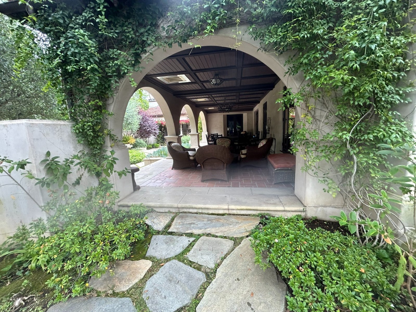 Wrought iron courtyard gate and patio fence under a stucco arch in Altadena