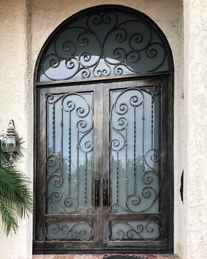 Arched wrought iron double entry door with scroll design