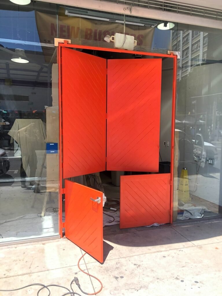 Custom red-painted steel storefront entry frame and doors fabricated for a new business in Downey