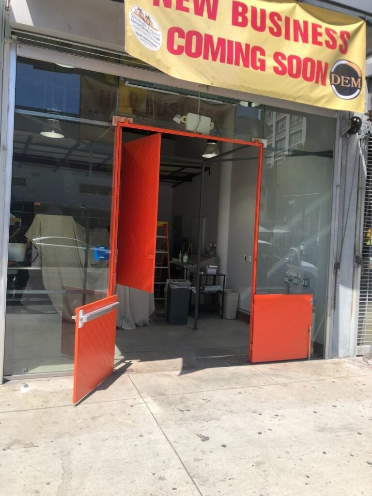 Custom red-painted steel storefront entry frame and doors fabricated for a new business in Downey