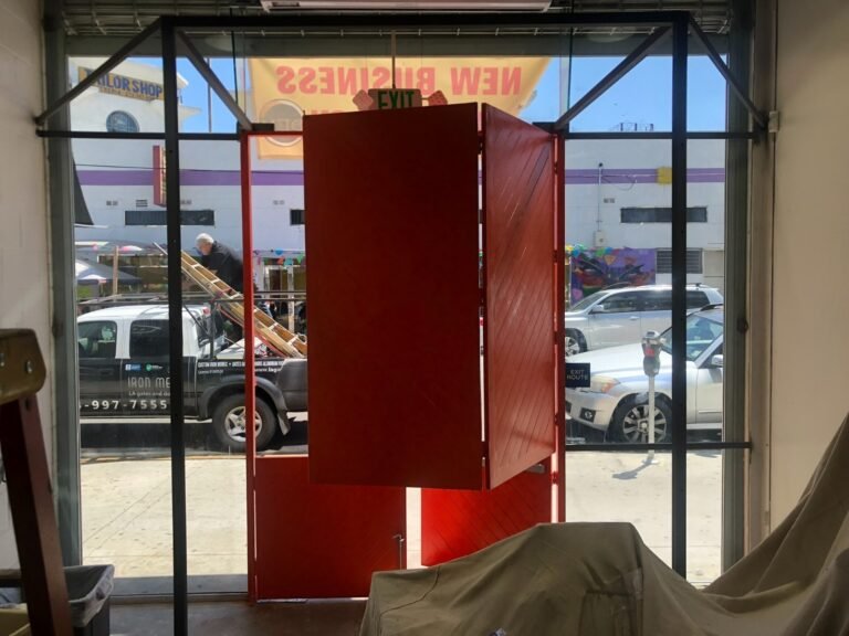 Custom red-painted steel storefront entry frame and doors fabricated for a new business in Downey