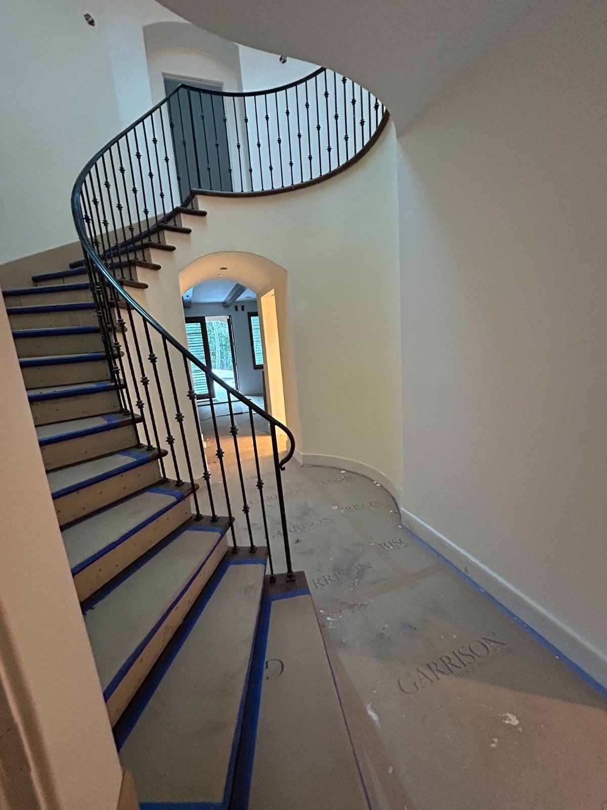 Custom curved wrought iron staircase railing with round balusters in a Bel Air home