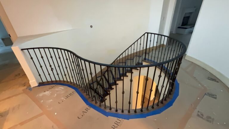 Custom curved wrought iron staircase railing with round balusters in a Bel Air home
