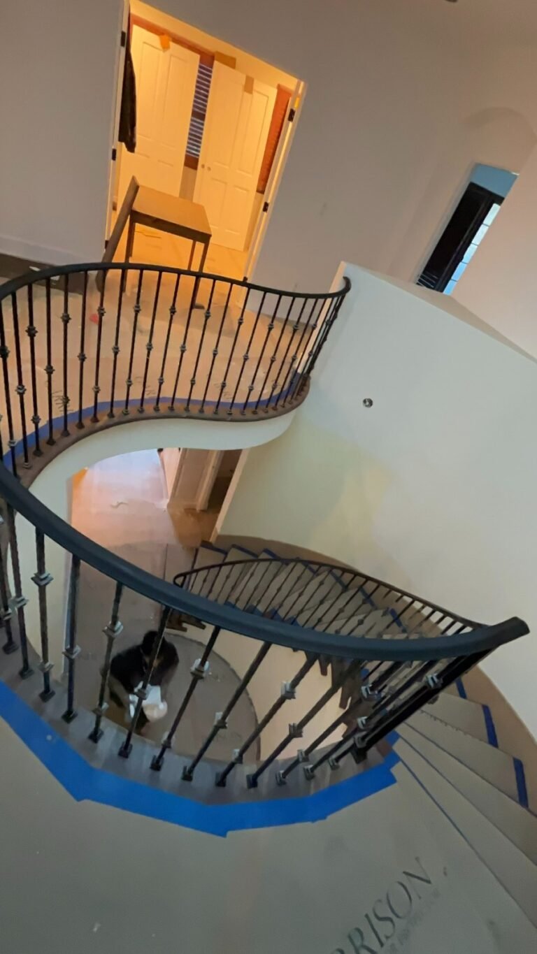 Custom curved wrought iron staircase railing with round balusters in a Bel Air home
