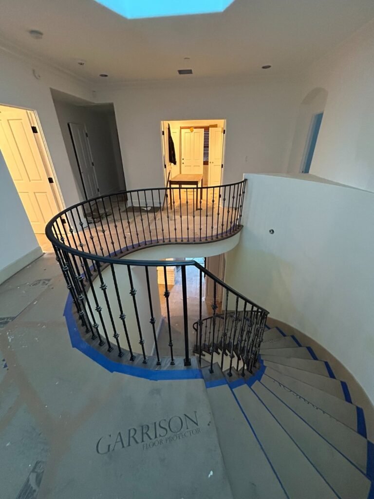 Custom curved wrought iron staircase railing with round balusters in a Bel Air home