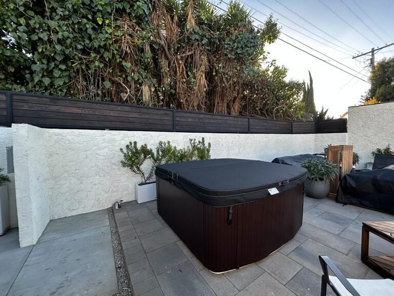 Black steel privacy screen along a patio wall near a hot tub