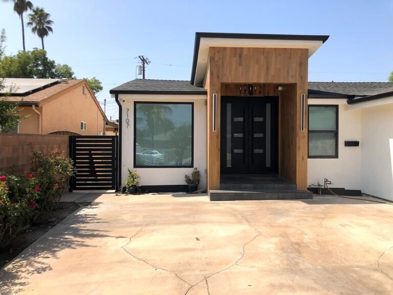 Black iron side gate beside a modern home entry