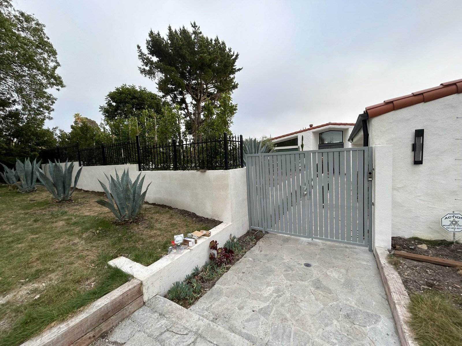 Gray solid steel side gate at the end of a garden walkway in Agoura Hills