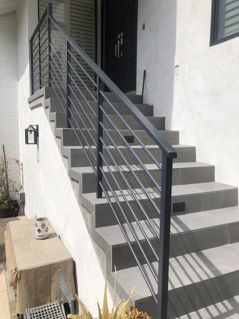 Dark steel horizontal bar railing along outdoor front entry steps in Hollywood Hills