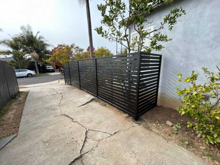 Black horizontal slat steel fence along a sidewalk in Westchester