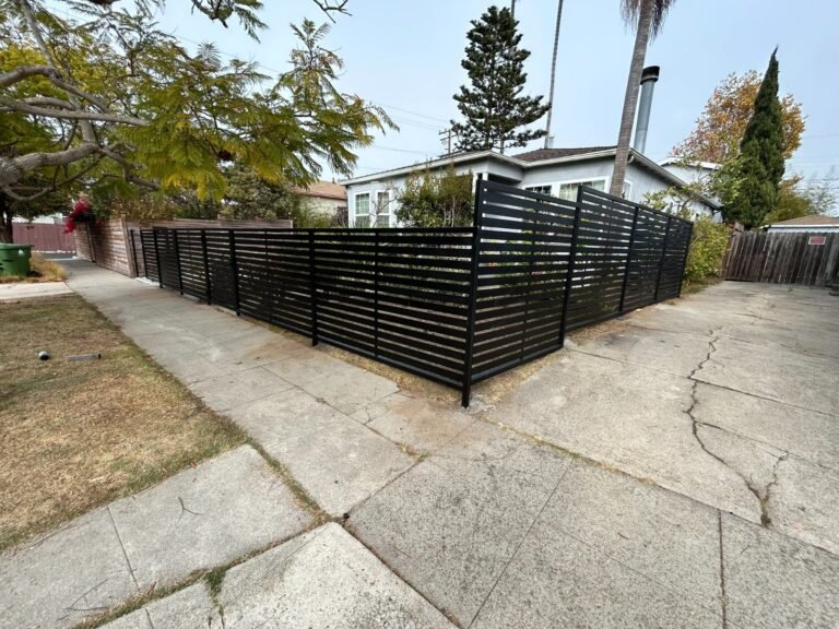 Black horizontal slat steel fence along a sidewalk in Westchester
