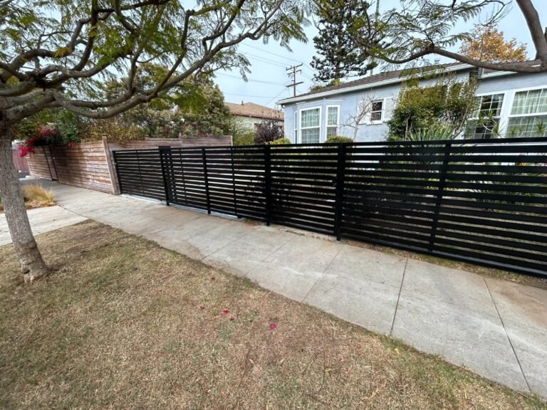 Black horizontal slat steel fence along a sidewalk in Westchester