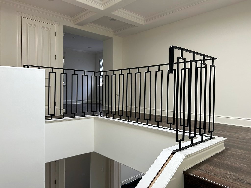Black interior iron stair railing with rectangular balusters