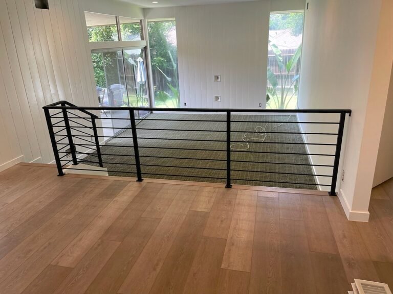 Modern black iron railing with horizontal bars around an open loft with wood floors