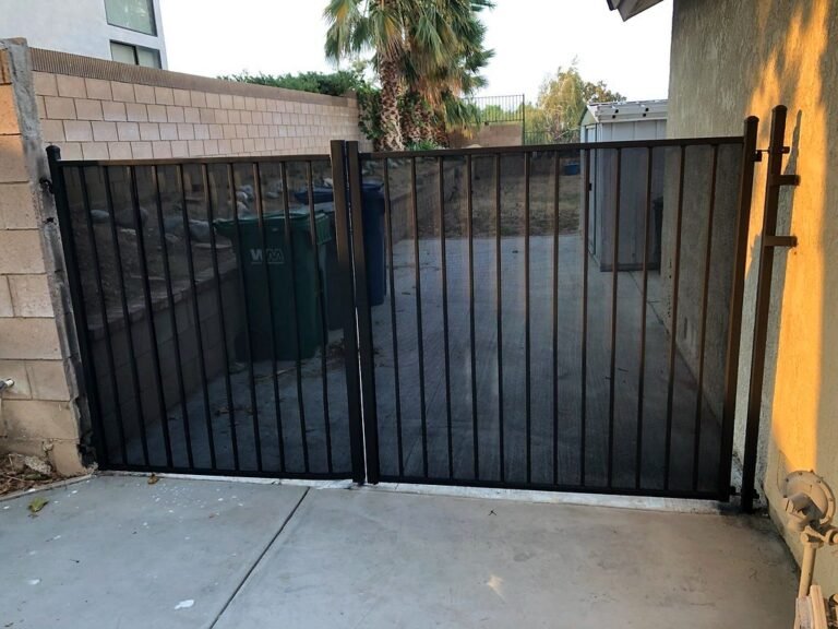 Black iron double gate across a side driveway