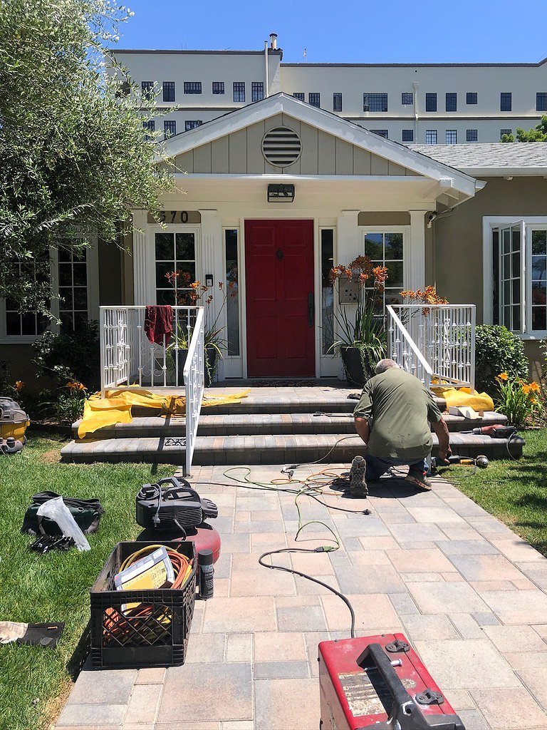 Crew installing iron railings at a front porch