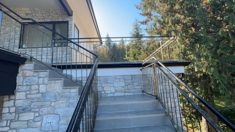 Black steel deck and stair railings on a covered patio overlooking a lake in Westlake Village