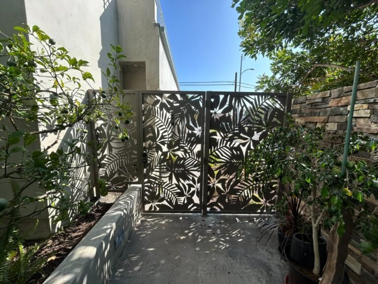 Laser-cut decorative steel panel side gate with a leaf pattern in Eagle Rock