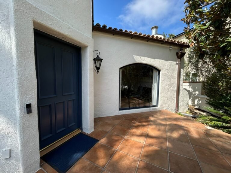 Navy blue steel entry door at a Spanish-style home in Santa Monica