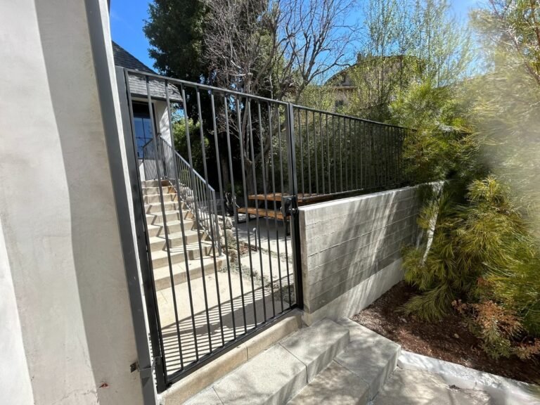 Black iron deck and stair railings overlooking a backyard pool in Castaic