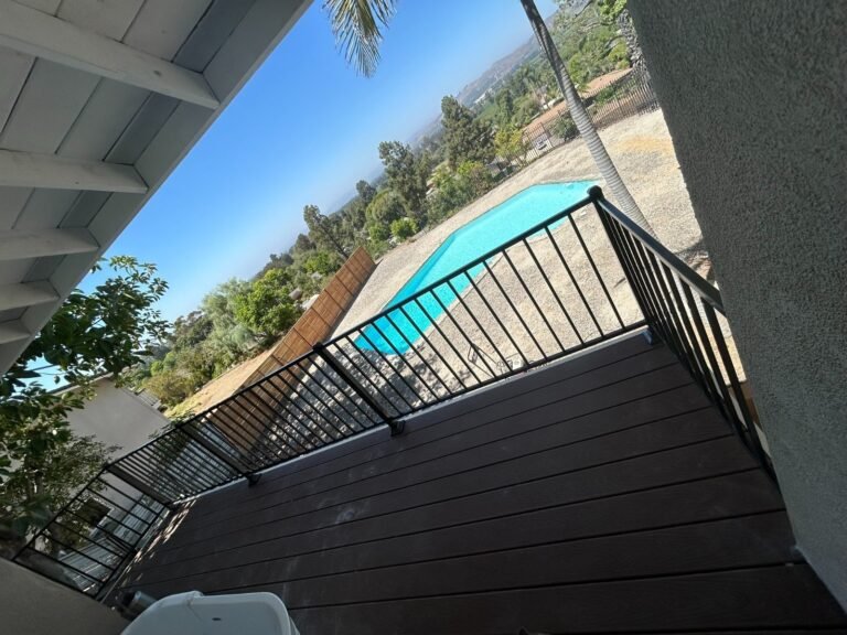 Black iron deck and stair railings overlooking a backyard pool in Castaic