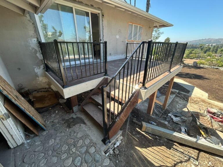Black iron deck and stair railings overlooking a backyard pool in Castaic