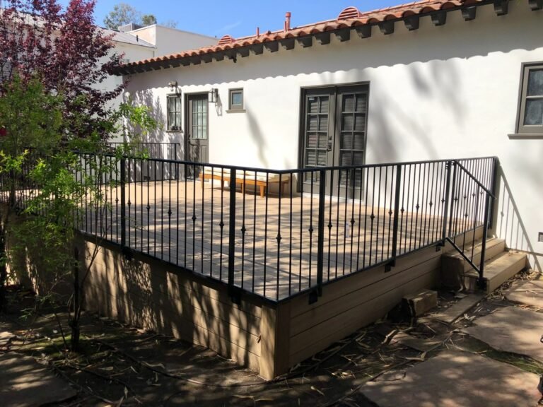 Black iron picket railing around a raised patio deck at a Spanish-style home in Highland Park