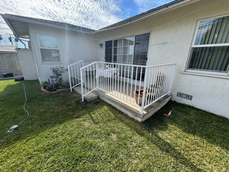 White iron porch and step railing at a single-story home in Lakewood