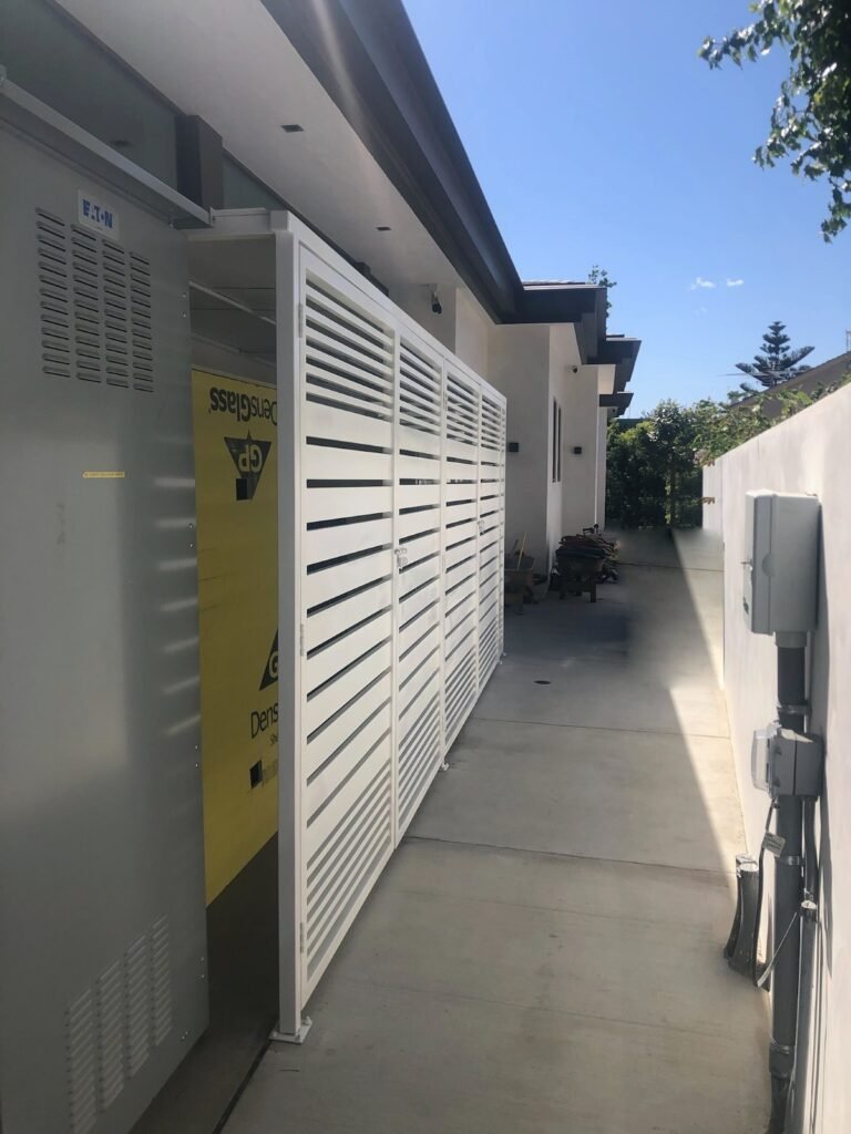 White horizontal slat metal enclosure along a side yard walkway