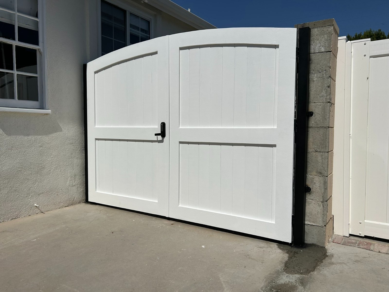 White solid steel driveway gate and matching side gate in Manhattan Beach